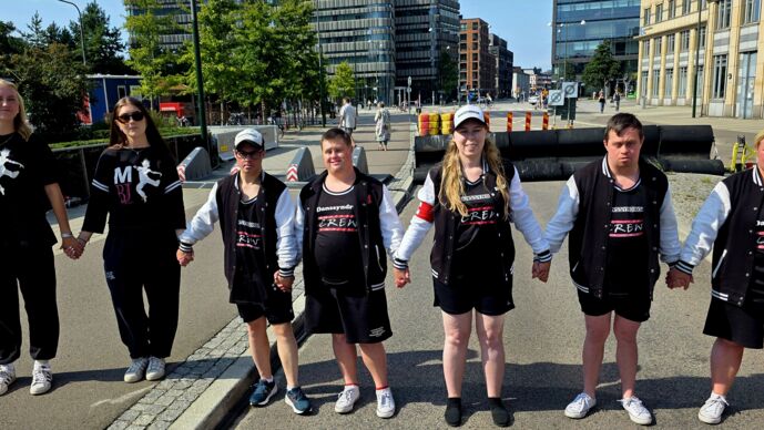 Danssyndroms deltagare på gatan.