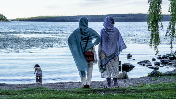 Två asylsökande kvinnor blickar ut över en sjö