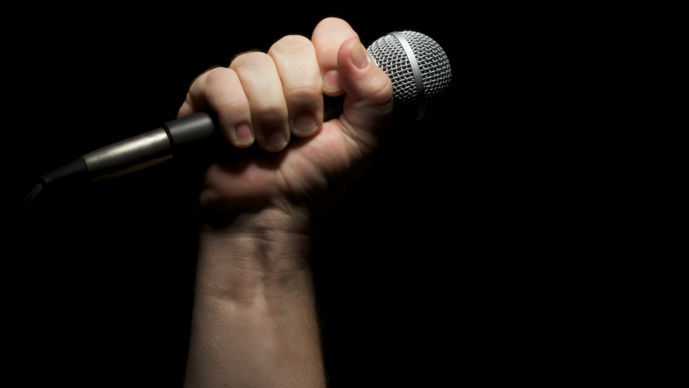 Bild på hand som håller i en mikrofon